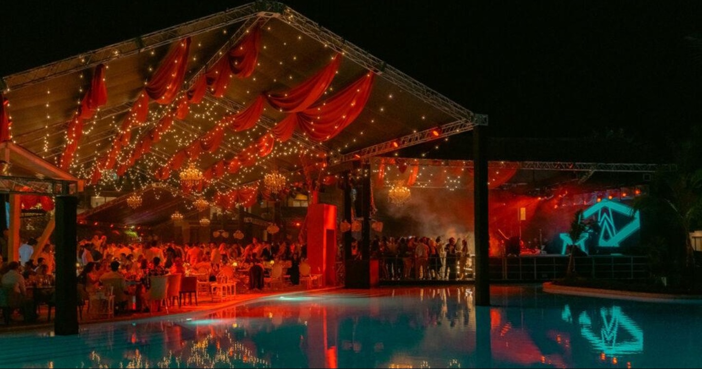Allegria at Cap Cana — poolside dining under red drapes and string lights