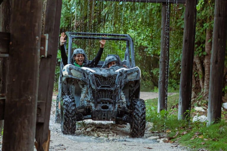Can-Am 4x4 buggy blasting through water at Scape Park Getaway Wheels in Cap Cana